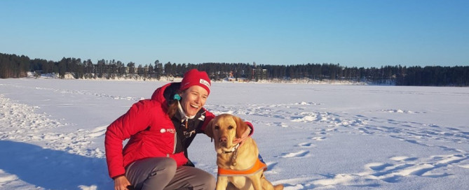 Vivian H. mit Führhund Candy auf einem zugefrorenen See der mit Schnee bedeckt ist, in Finnland