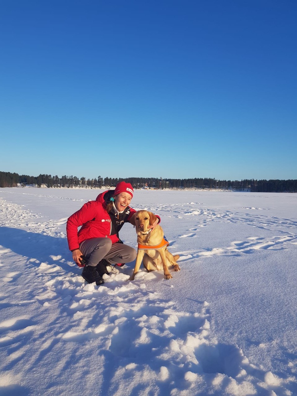 Vivian H. mit Führhund Candy auf einem zugefrorenen See der mit Schnee bedeckt ist, in Finnland