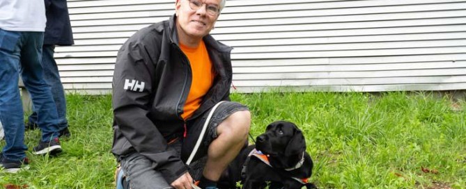 Stephan knieend im Gras , Isi liegt daneben